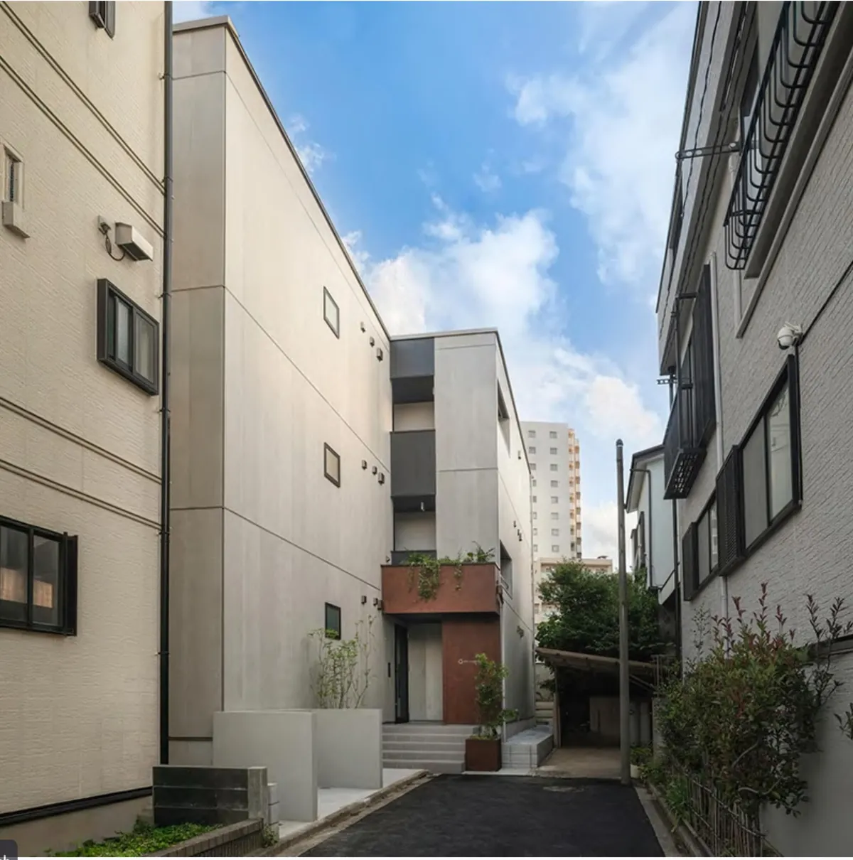 EN. ASAKADAIの外観。グレーの外壁の木造3階建てマンション